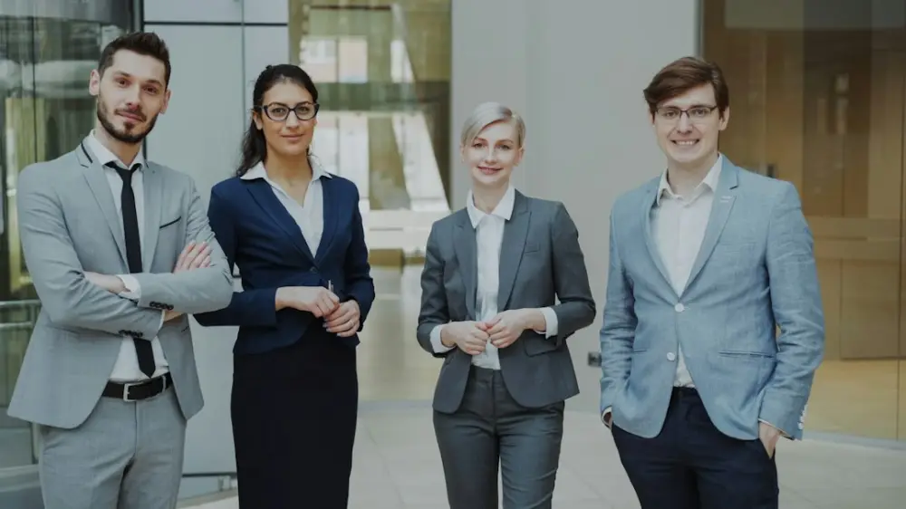 Four professionals in business attire stand together, illustrating professional leadership training